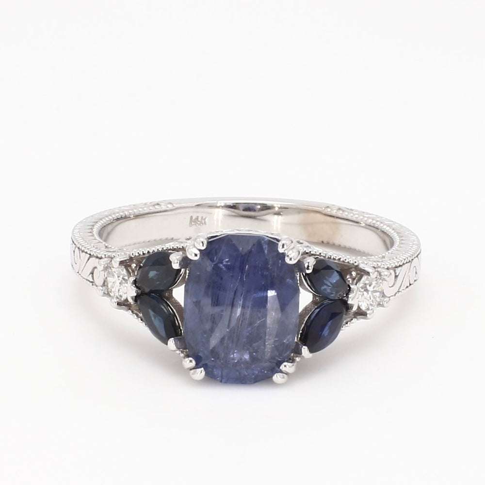 Vintage-inspired 14K white gold engagement ring featuring a natural blue sapphire center stone with diamond halo and milgrain detailing.