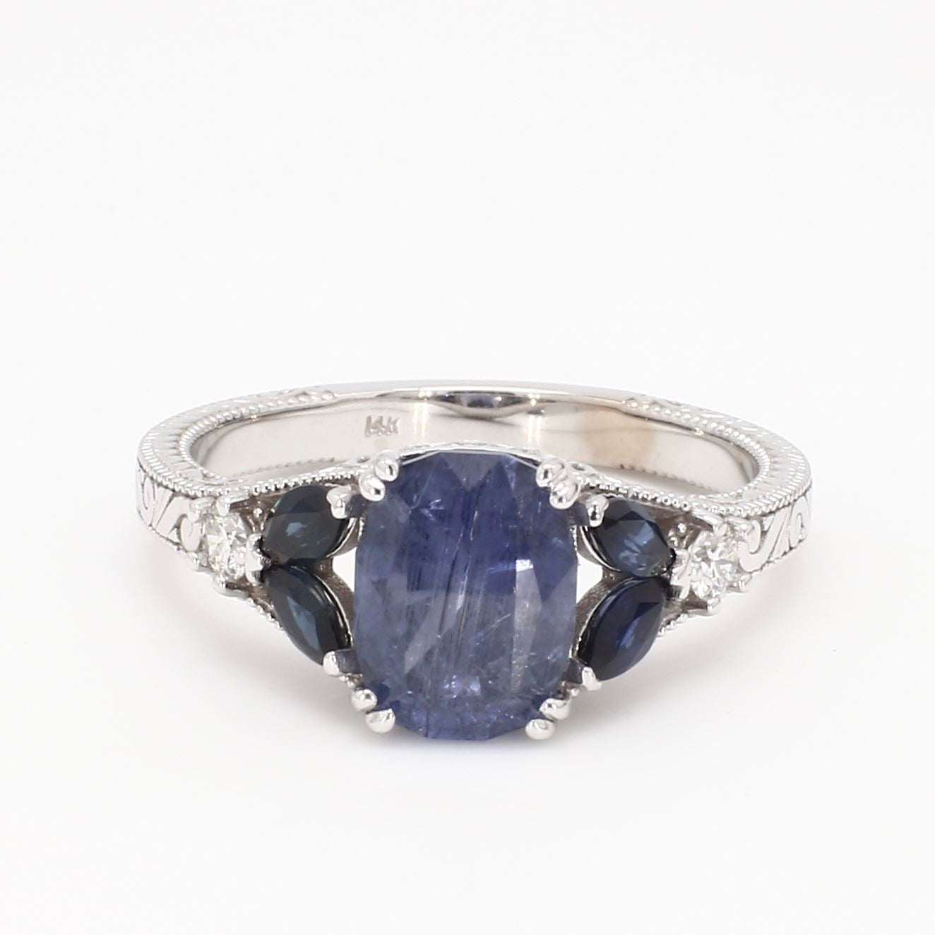 Vintage-inspired 14K white gold engagement ring featuring a natural blue sapphire center stone with diamond halo and milgrain detailing.