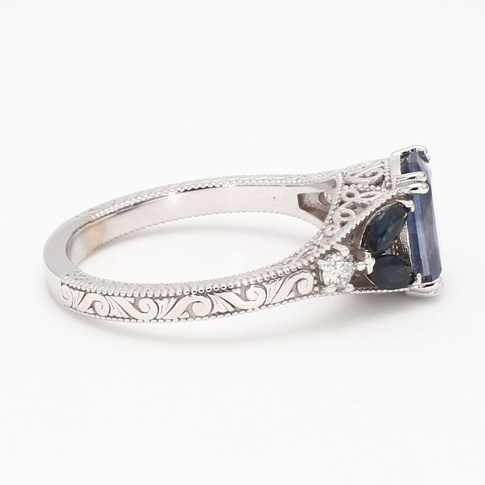 Vintage-inspired 14K white gold engagement ring featuring a natural blue sapphire center stone with diamond halo and milgrain detailing.