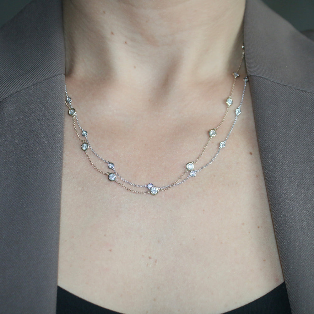 
                  
                    Delicate 14K gold diamond bezel station necklace featuring round brilliant diamonds set along an adjustable chain.
                  
                
