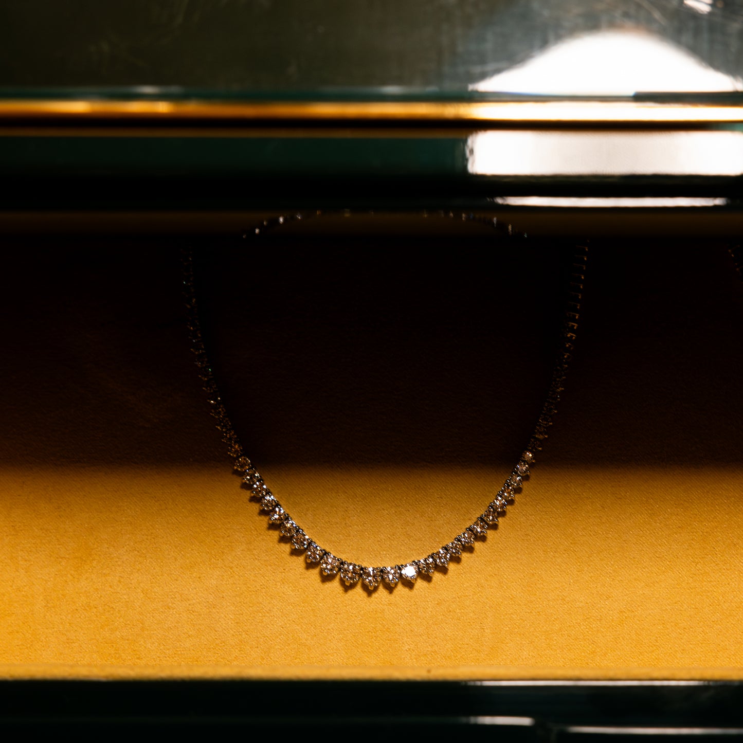 Necklace on a yellow cushion with a dark background