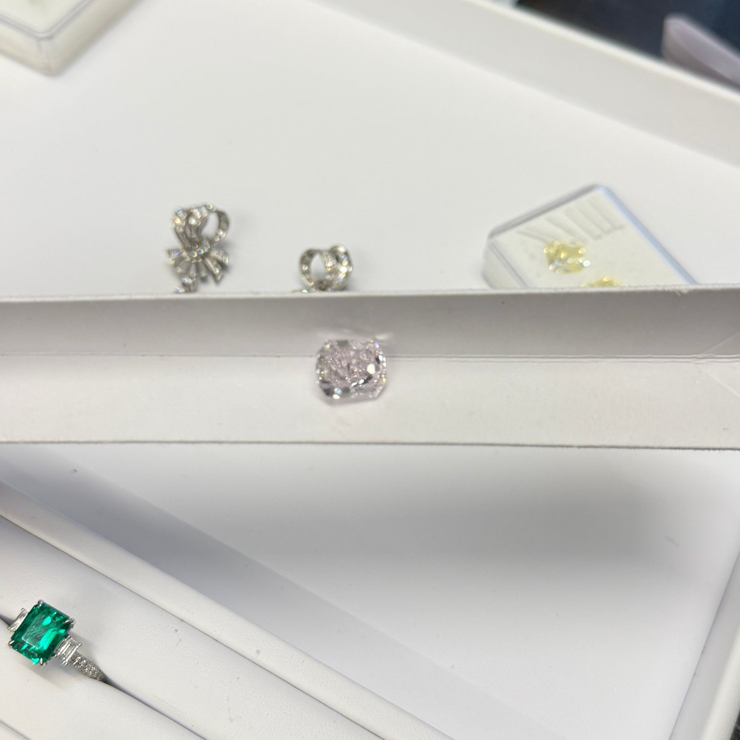 Jewelry display with earrings and a ring on a white surface