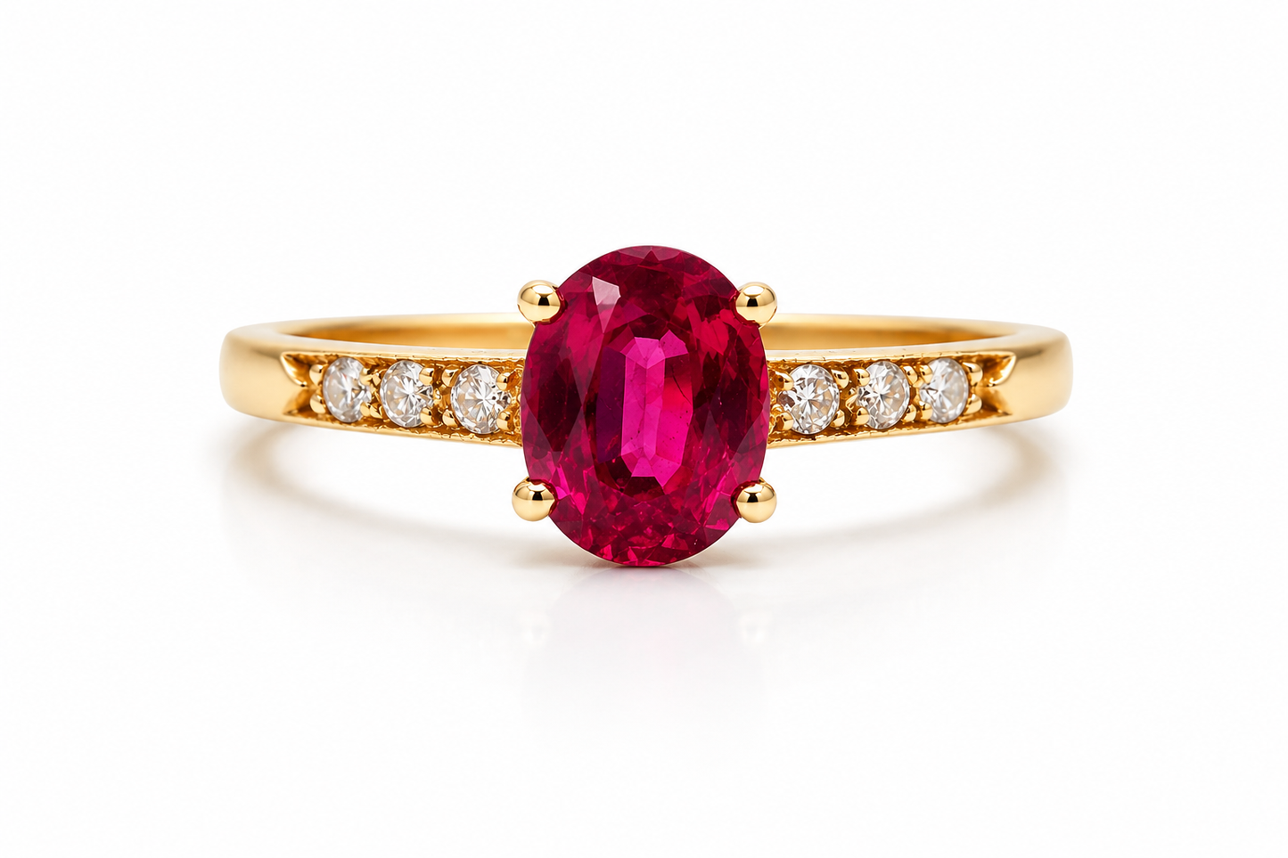A yellow gold ring featuring a large oval-cut deep pinkish-red ruby center stone, accented by small round diamonds set along the shoulders, shown on a clean white background.