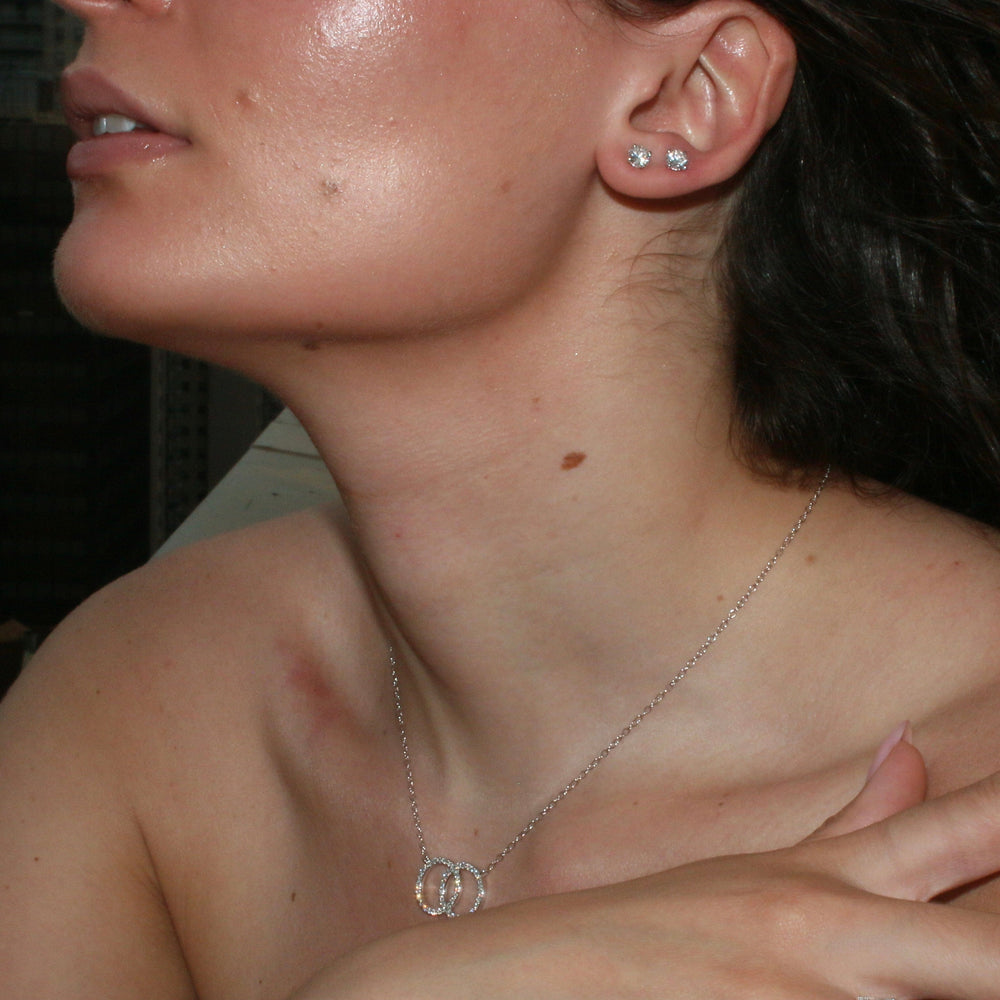 
                  
                    Woman wearing 1.00ct round diamond stud earrings in 14K white gold, styled for everyday elegance
                  
                