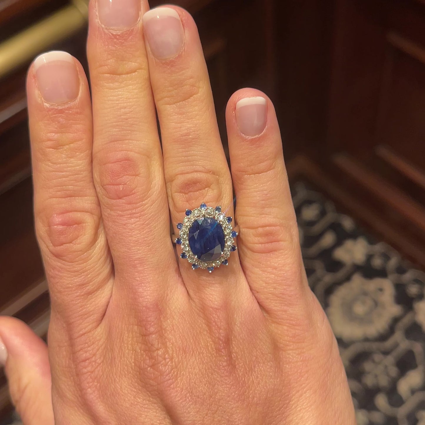 Laurenti Diana Ring featuring an oval blue sapphire surrounded by diamonds and sapphires in 14K white gold.